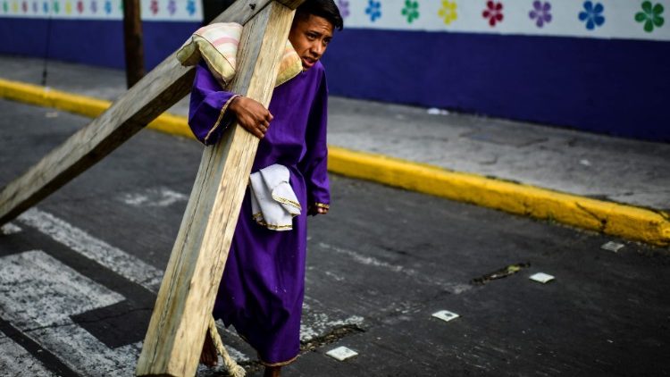 一位墨西哥年轻人在圣周五背十字架拜苦路摘自教宗清晨弥撒耶稣的平安